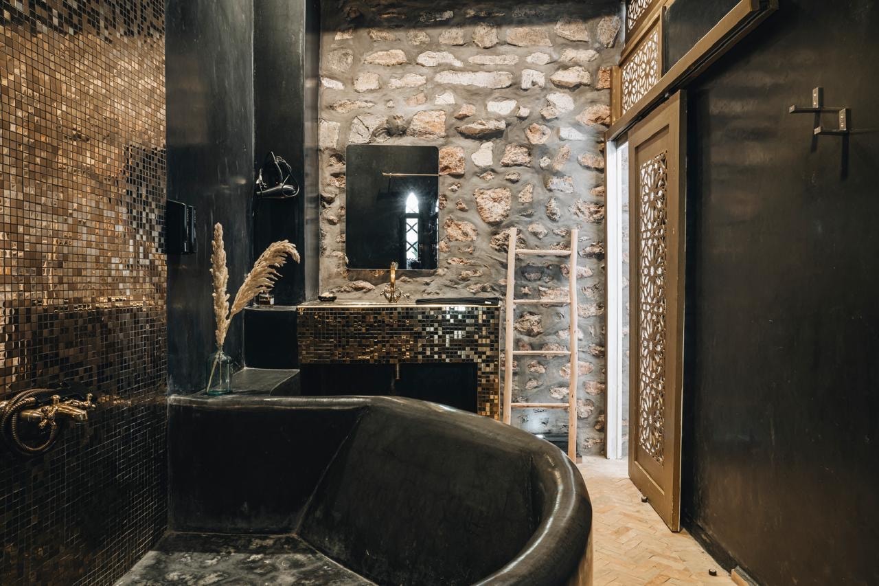 Villa bathroom with dark stone finishes, Morocco retreat