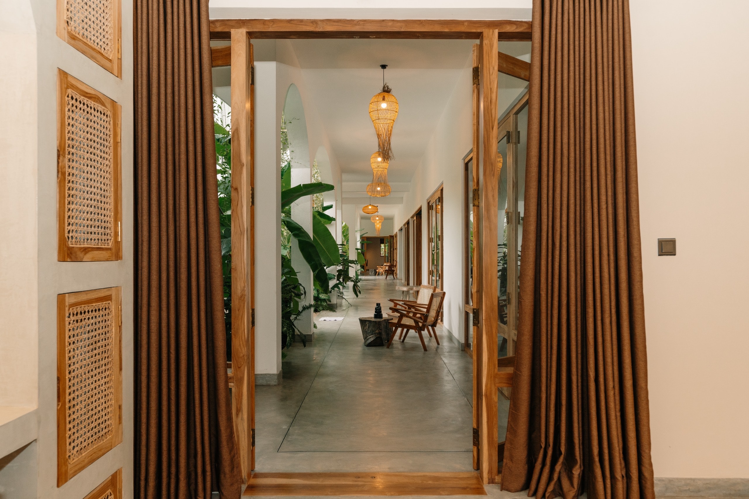 Villa Oura Spirit teak door corridor with rattan pendants